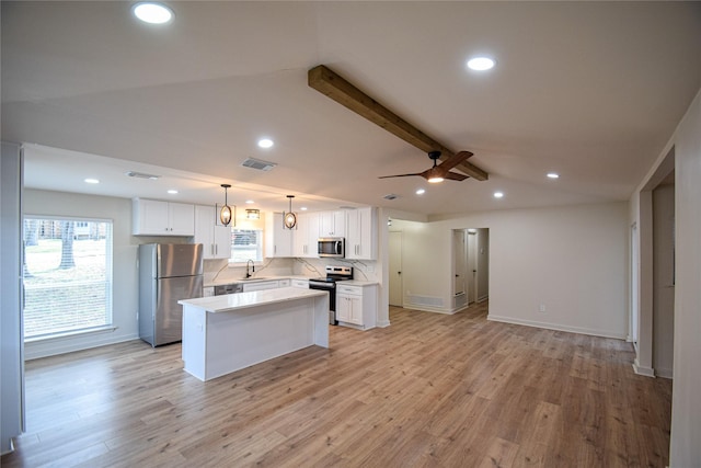 kitchen featuring white cabinets, stainless steel appliances, pendant lighting, and a center island