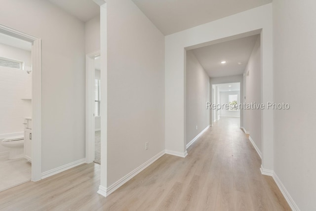 hallway with light hardwood / wood-style floors