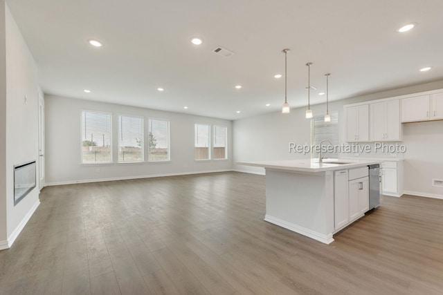 kitchen with white cabinetry, sink, a center island with sink, and pendant lighting