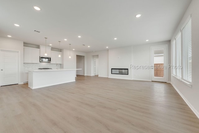 unfurnished living room with light wood-type flooring