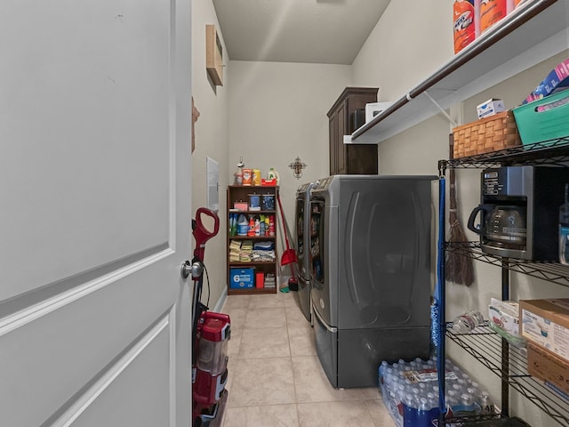 washroom with cabinets, washer and dryer, and light tile patterned floors