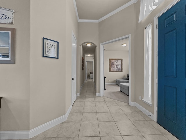 hall with ornamental molding and light tile patterned floors