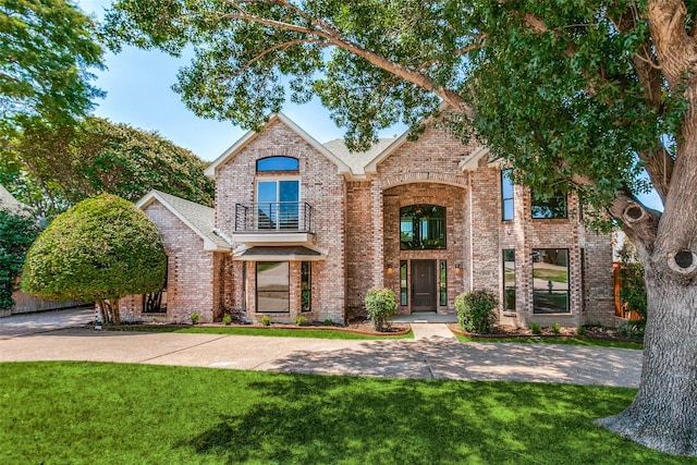 view of front of property with a balcony and a front lawn