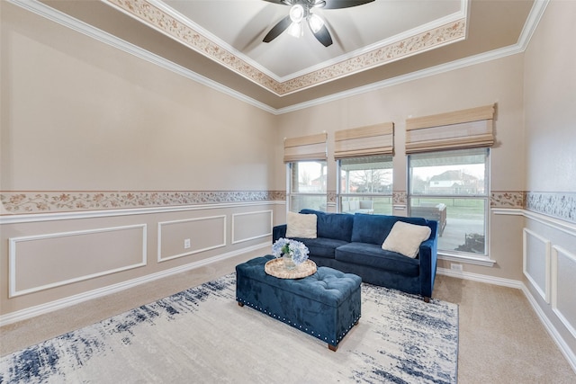 carpeted living room with crown molding and ceiling fan