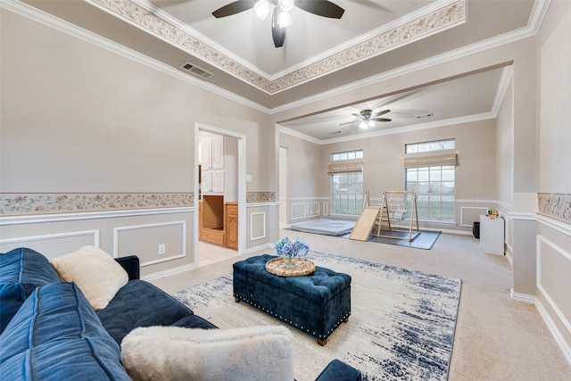 carpeted living room featuring a raised ceiling and crown molding