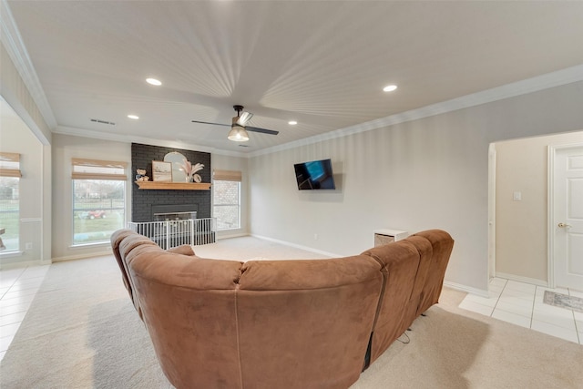 carpeted living room with a brick fireplace, crown molding, and ceiling fan