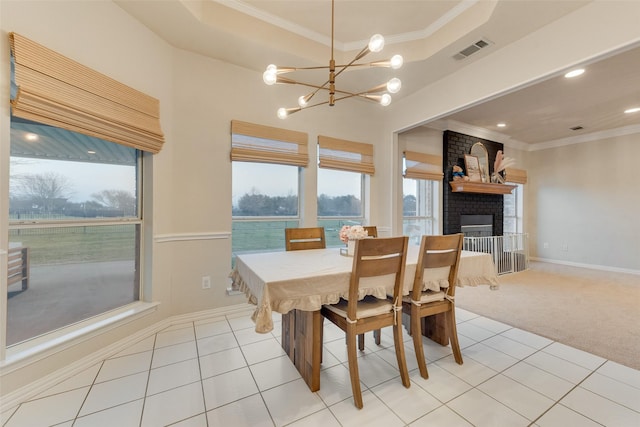 dining area with crown molding, a water view, a fireplace, and light tile patterned floors