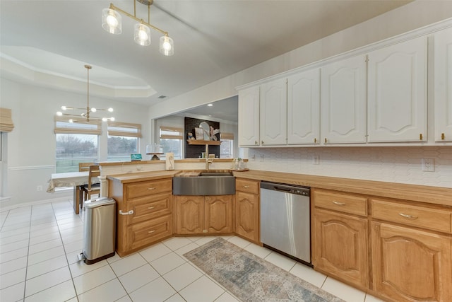 kitchen with dishwasher, sink, hanging light fixtures, light tile patterned floors, and a tray ceiling