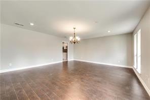 empty room featuring dark hardwood / wood-style floors and a chandelier