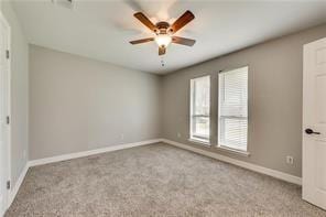 empty room featuring ceiling fan and light colored carpet