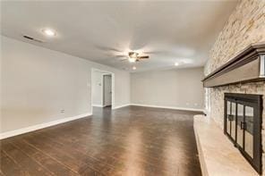 unfurnished living room featuring ceiling fan, a fireplace, and dark hardwood / wood-style floors