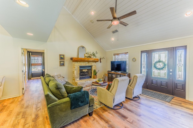 living room featuring wood ceiling, ceiling fan, high vaulted ceiling, a fireplace, and light hardwood / wood-style floors