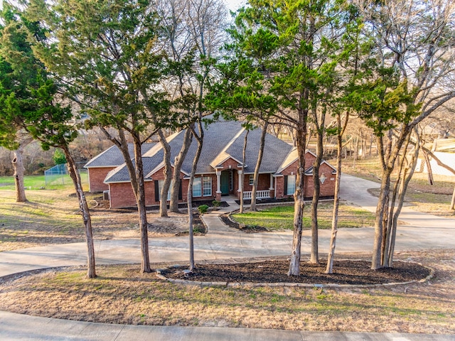 view of front facade with driveway and brick siding