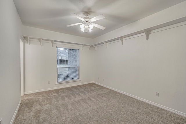 spare room with light colored carpet, ceiling fan, and baseboards