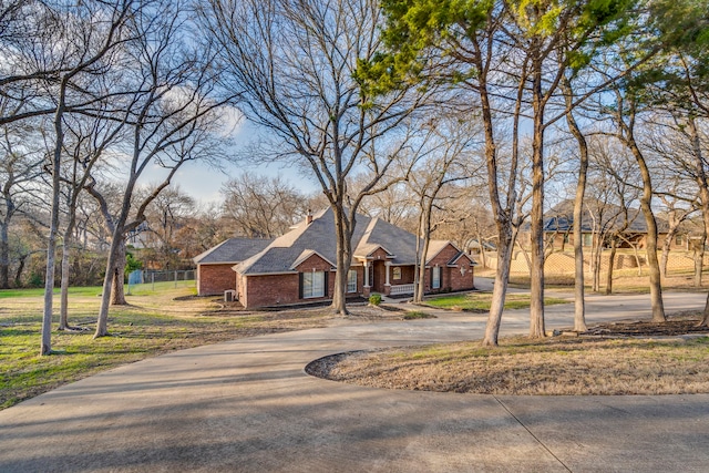 view of front of house featuring brick siding, driveway, and a front yard