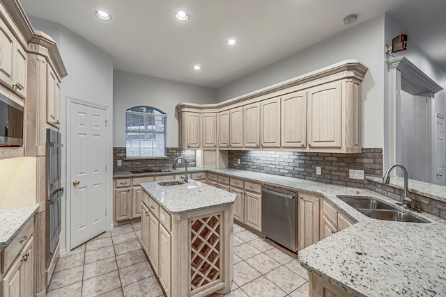 kitchen featuring light brown cabinetry, a sink, and a kitchen island with sink