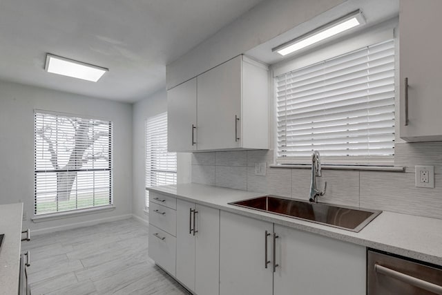 kitchen featuring white cabinets, dishwasher, sink, and backsplash