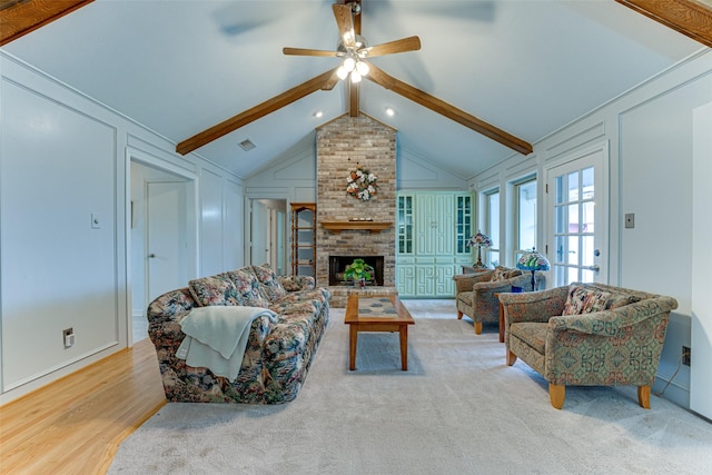 living room featuring a fireplace, lofted ceiling with beams, light hardwood / wood-style floors, and ceiling fan