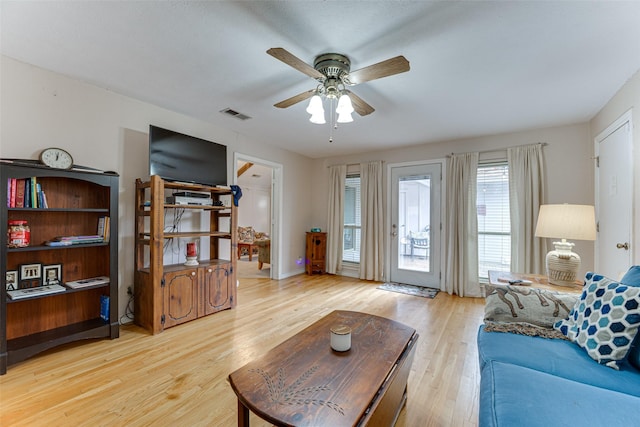 living room featuring light hardwood / wood-style flooring and ceiling fan