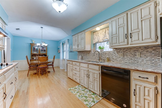 kitchen with pendant lighting, sink, cream cabinetry, black appliances, and light hardwood / wood-style flooring