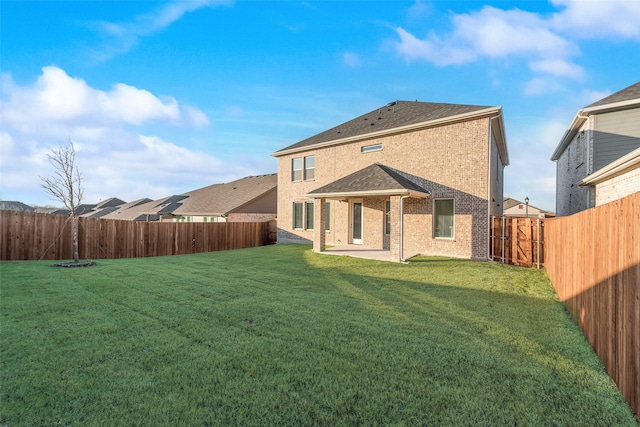 back of property with a yard and a patio