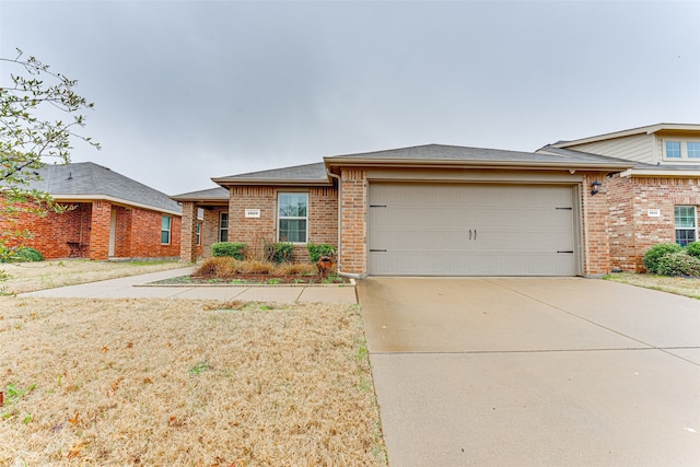 view of front of home with driveway, brick siding, a shingled roof, and an attached garage