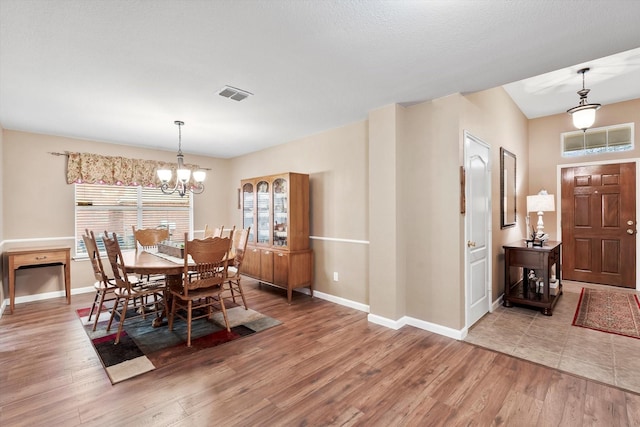 dining room with an inviting chandelier and hardwood / wood-style flooring