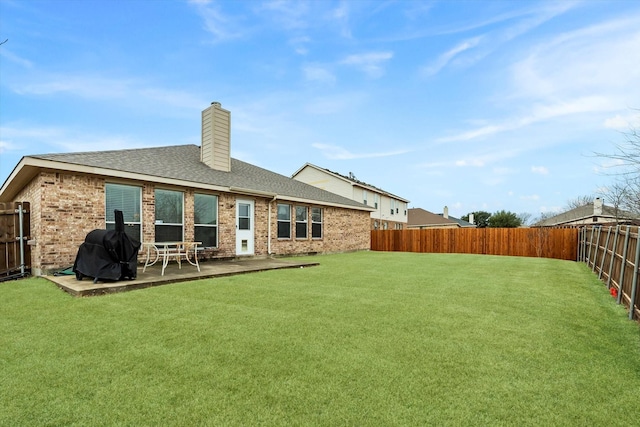 back of house with a patio area and a lawn