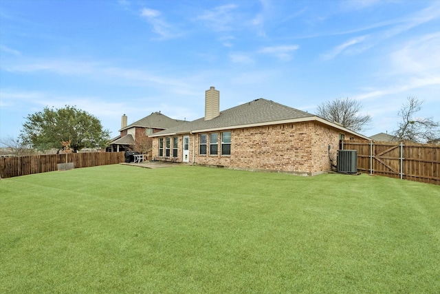 back of house with cooling unit and a yard