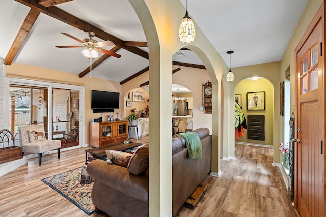 living room featuring lofted ceiling with beams, ceiling fan, and light hardwood / wood-style floors