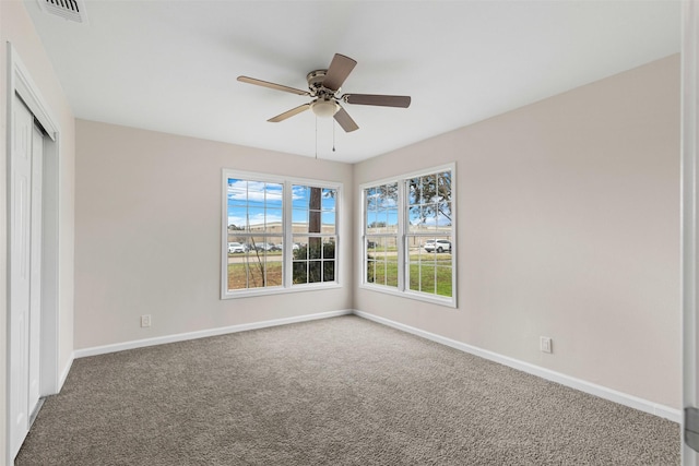 empty room with ceiling fan and carpet flooring