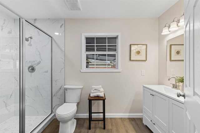 bathroom featuring wood-type flooring, toilet, a shower with shower door, and vanity