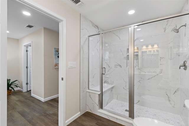 bathroom featuring wood-type flooring and a shower with door