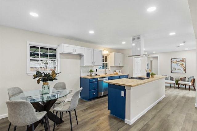 kitchen with blue cabinetry, wooden counters, appliances with stainless steel finishes, island range hood, and white cabinets