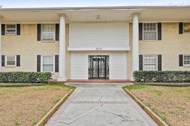 view of exterior entry featuring a lawn