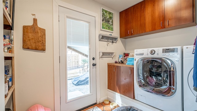 laundry room featuring separate washer and dryer and cabinets