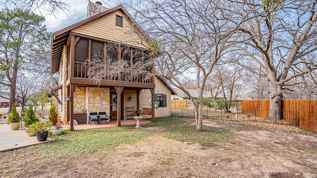 rear view of property featuring a sunroom and a patio area