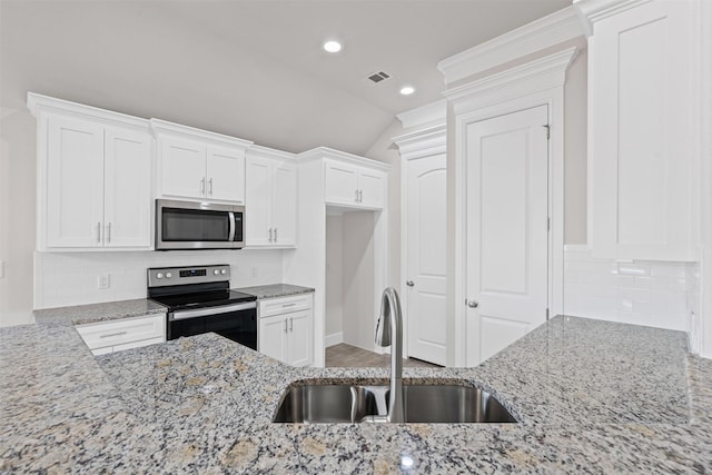 729 Jameson, Springtown, TX 76082 - kitchen with appliances with stainless steel finishes, a sink, white cabinets, light stone counters, and vaulted ceiling