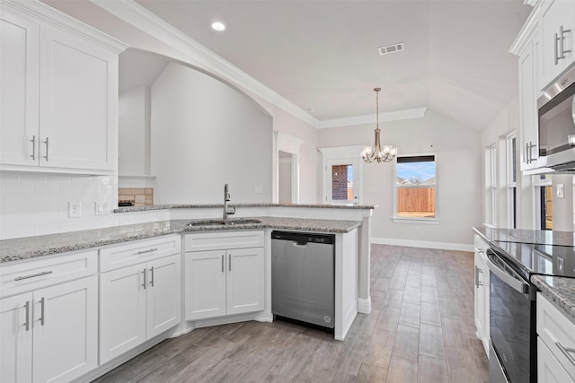 729 Jameson, Springtown, TX 76082 - kitchen with a sink, stainless steel appliances, a chandelier, a peninsula, and white cabinets