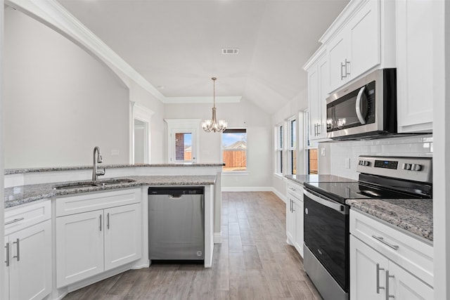 729 Jameson, Springtown, TX 76082 - kitchen featuring stainless steel appliances, a sink, a chandelier, white cabinets, and vaulted ceiling