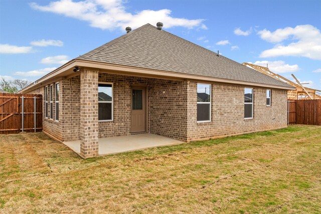729 Jameson, Springtown, TX 76082 - rear view of property with a shingled roof, brick siding, and a patio