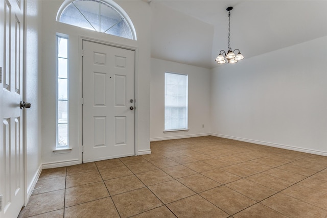 tiled entrance foyer with a towering ceiling and a notable chandelier