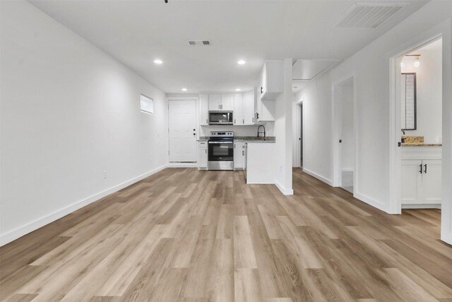 unfurnished living room with sink and light hardwood / wood-style flooring