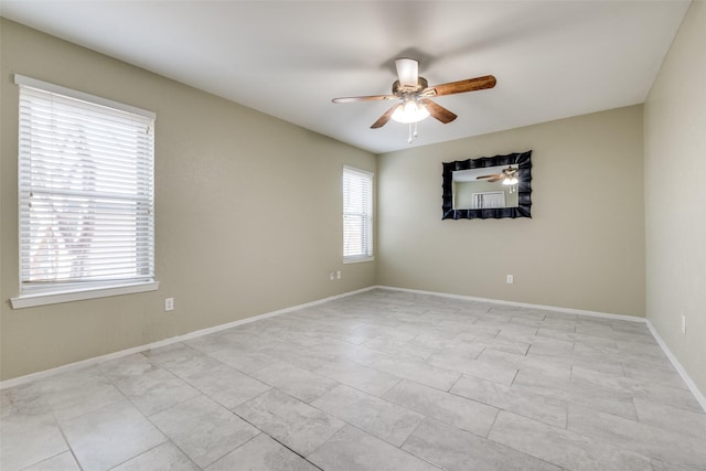 unfurnished room with ceiling fan and baseboards