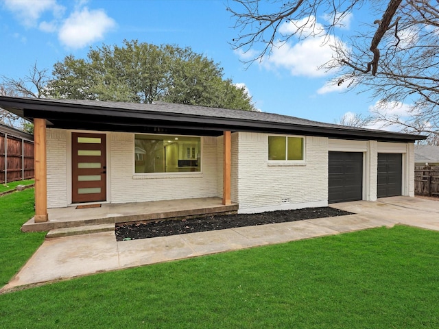 view of front of home with a garage, covered porch, and a front lawn