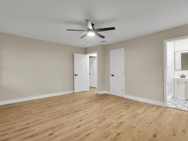 unfurnished bedroom with ceiling fan, sink, connected bathroom, and light hardwood / wood-style floors