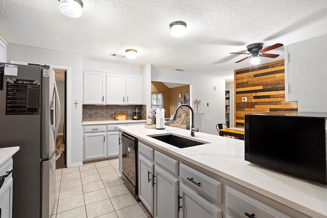 kitchen with stainless steel refrigerator with ice dispenser, black dishwasher, sink, and white cabinets