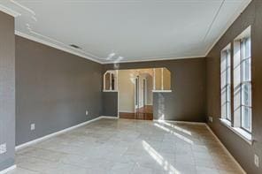 spare room with crown molding and a healthy amount of sunlight