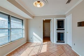 unfurnished room featuring crown molding, a fireplace, and light tile patterned flooring