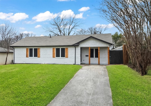 ranch-style home with a front yard, fence, and driveway